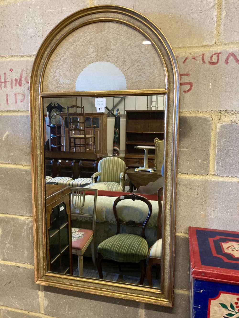 A modern gilt framed wall mirror, the arched top with an inset lacework panel, width 59cm, height 112cm